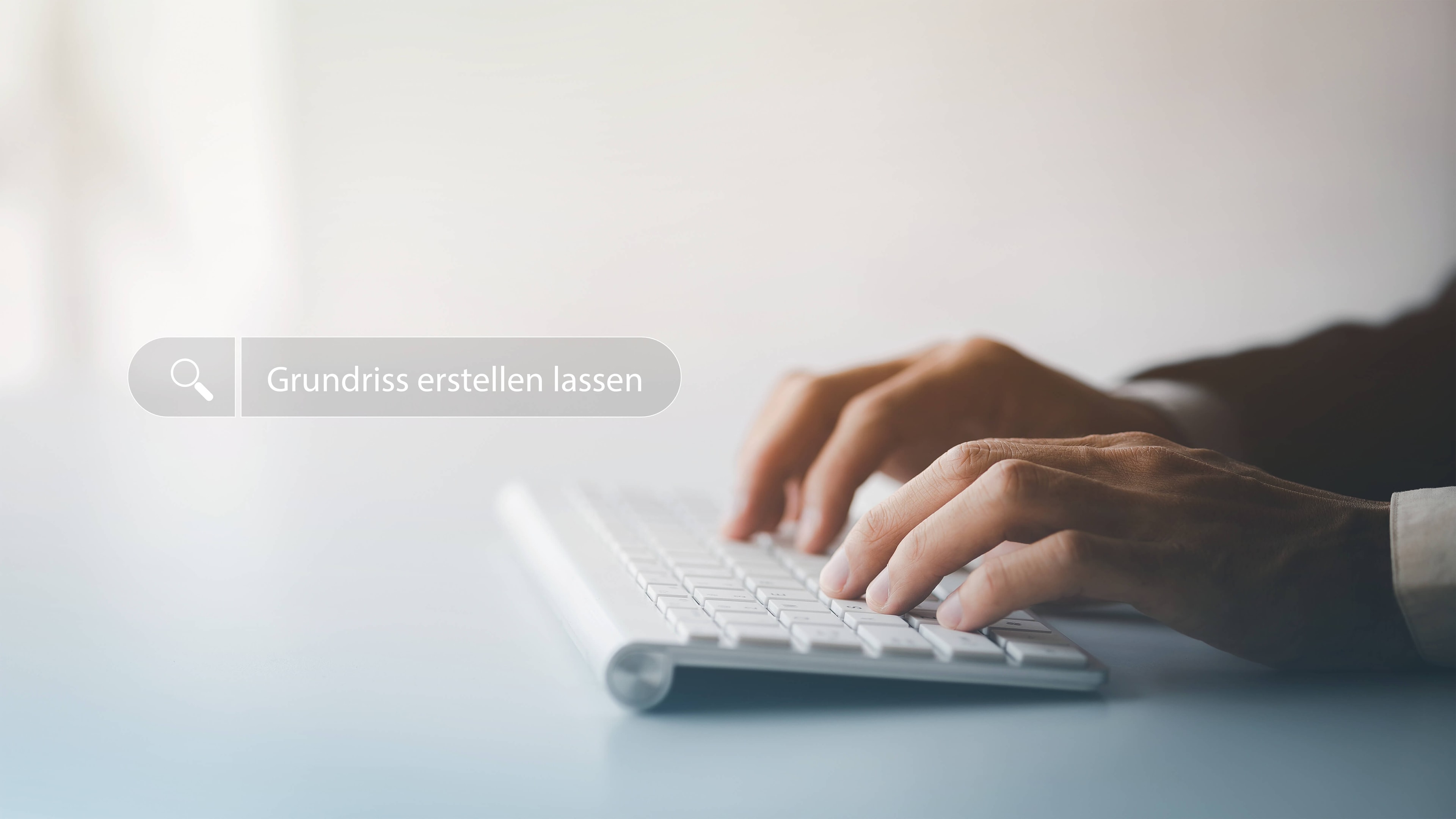 Zwei Hände an einer flchen Tastatur mit einem virtuellen Suchfeld darüber schwebend, in dem 'Grundriss erstellen lassen' steht.